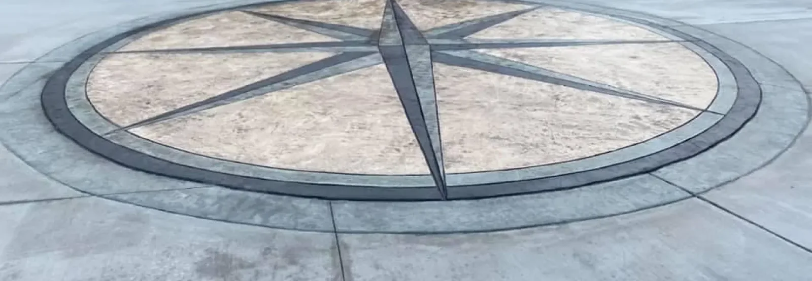 Stamped concrete driveway with a hand-carved compass star