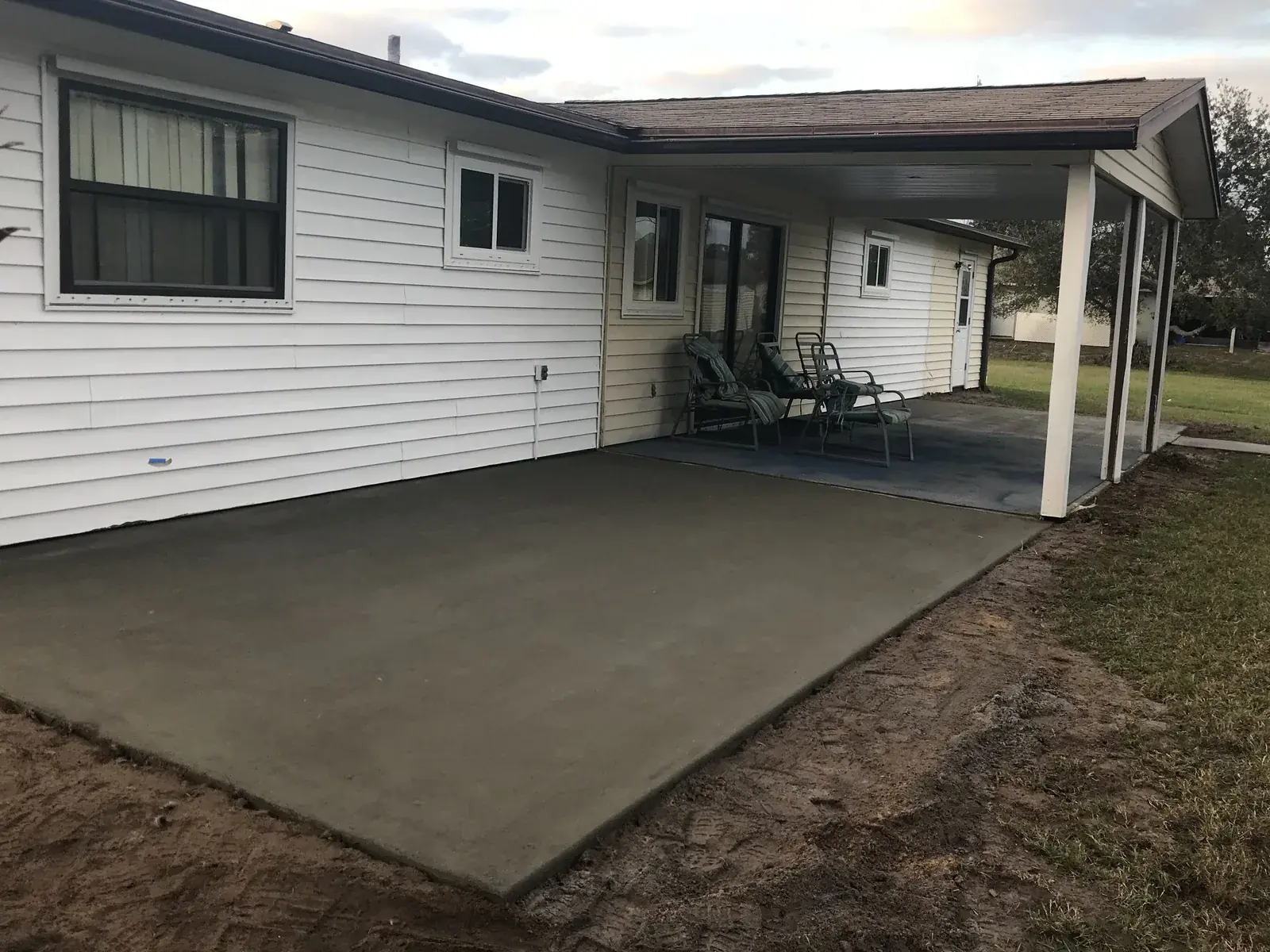 Concrete patio extension poured off a covered carport patio