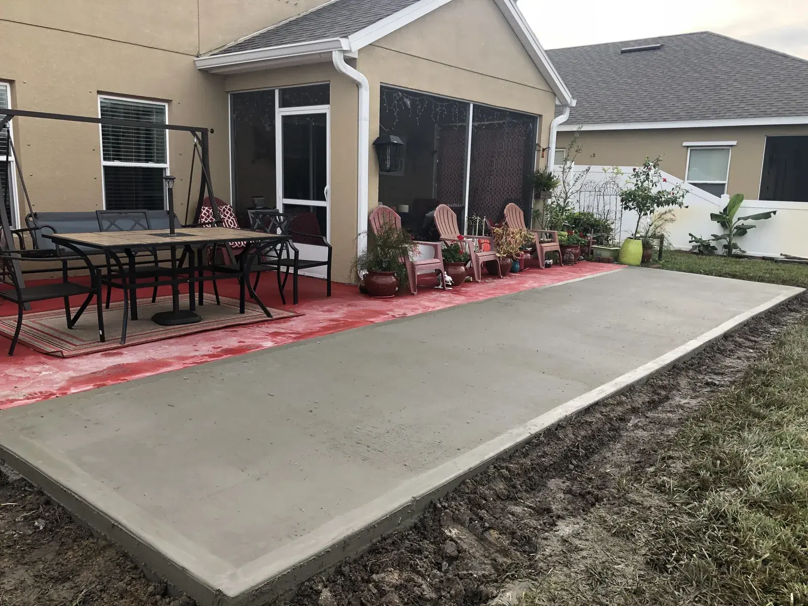 Concrete patio extension poured beside an existing painted patio
