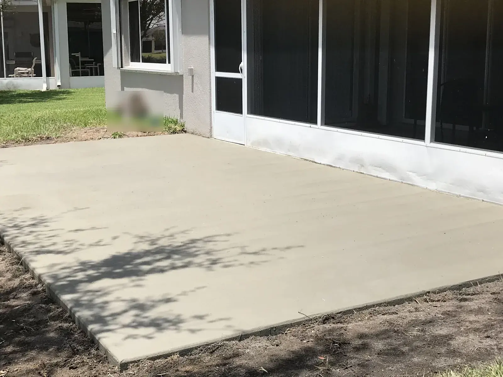 Concrete patio slab poured beside a screened enclosure