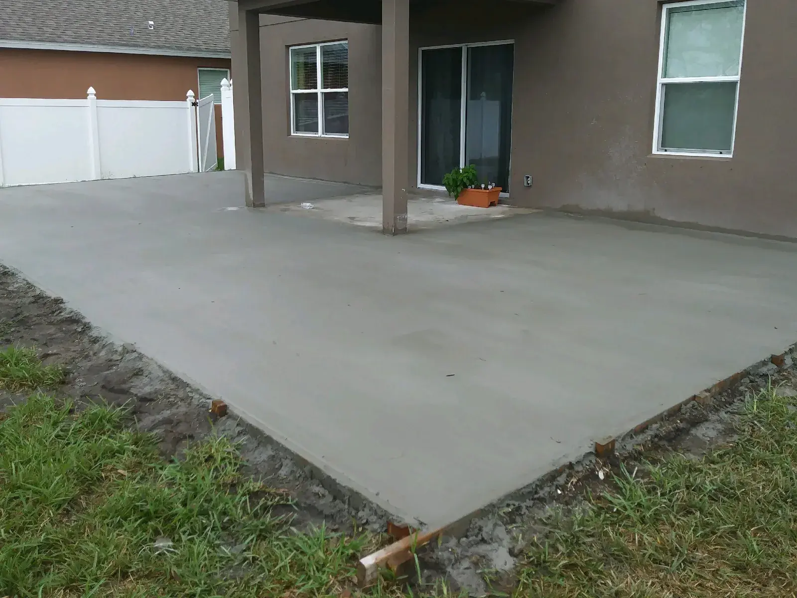 Large broom finished concrete patio slab behind a two story home