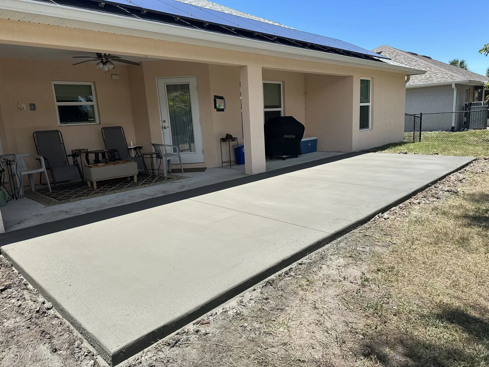 Broom finished concrete slab extension along the back of a home