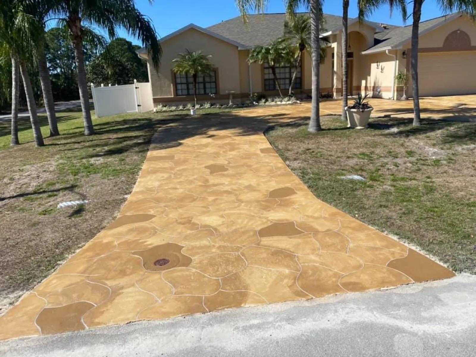 Flagstone pattern stamped concrete driveway with a tan stain