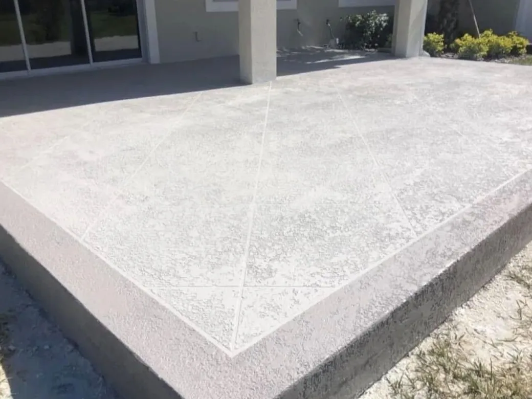 Gray spray texture finish with diamond score lines on a raised concrete patio