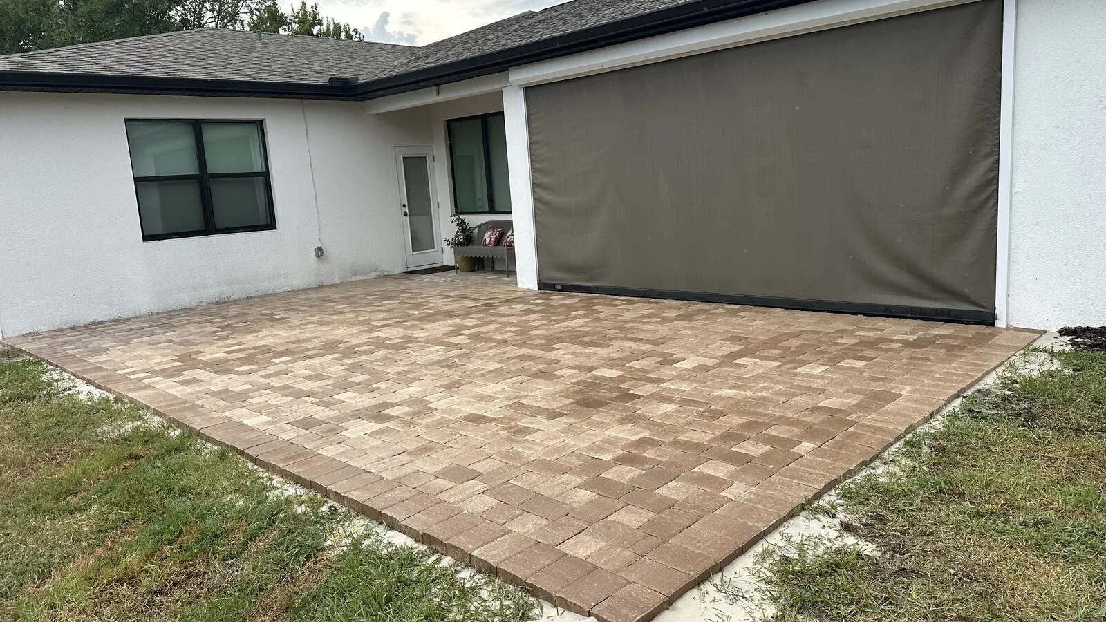 Tan paver patio under a screened lanai