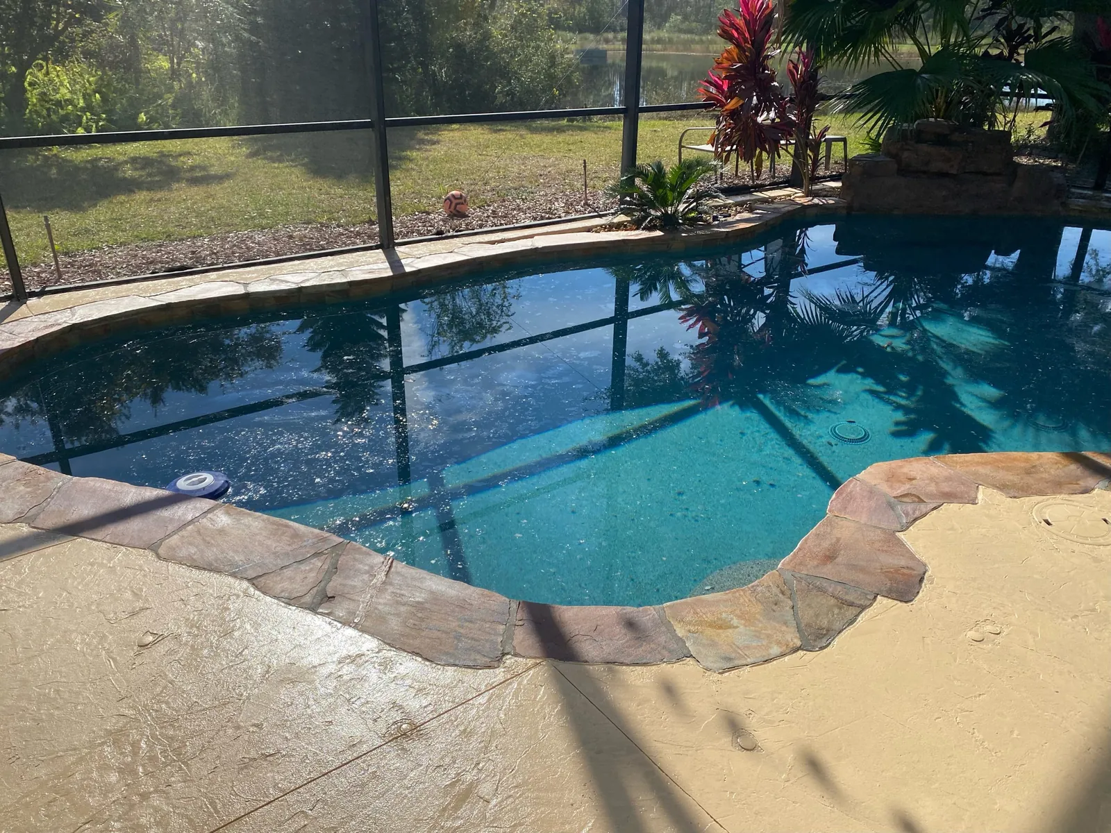 Stone look coping around a screened pool